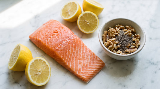 Fresh salmon, lemons, and walnuts on marble, whole-food omega-3 sources relevant to fish oil for fatty liver research.