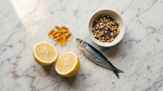 Amber omega-3 softgels with lemon, sardine, and walnuts illustrating the balance between omega-3 and omega-6