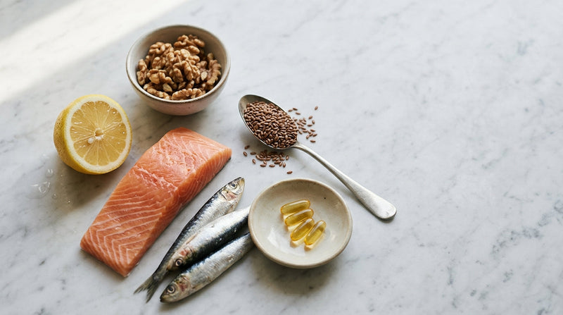 Salmon, sardines, walnuts, flaxseed and softgels on marble — omega-3 deficiency and food sources