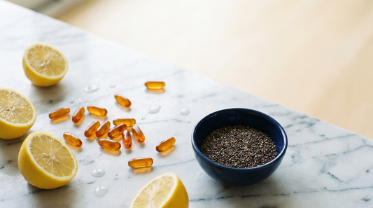 Editorial flat-lay of amber omega-3 softgels and fresh lemons on marble illustrating an omega-3 index lifestyle